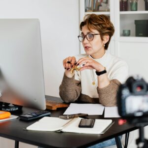 Confident elegant lady in eyeglasses hosting webinar
